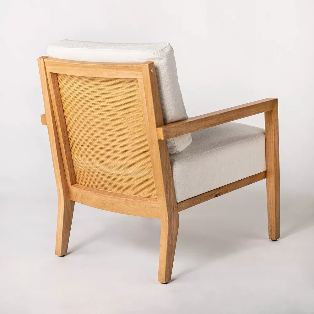 Hands repairing a loose strand on an accent chair cane back.