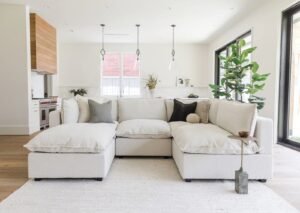 A comfortable grey couch sits in a bright, modern apartment living room.