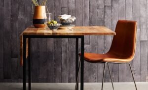 A compact oak dining table perfectly staged in a sunny small apartment dining area.