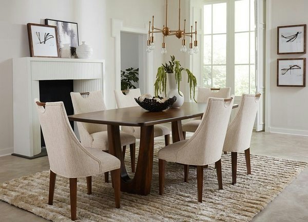 Hands fitting a fabric slipcover onto a dining chair to refresh its living room appearance.