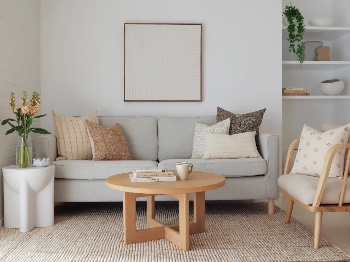 Three decorative cushions arranged neatly on the corner of a modern three-seater sofa.