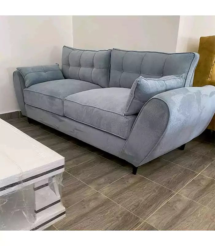 A tablet showing furniture price comparisons near a 3 seater sofa.