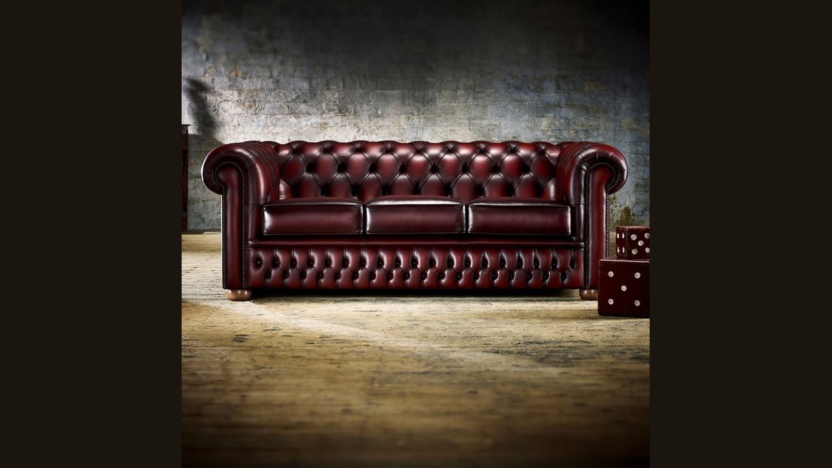 A modern 3 seater sofa sits in a bright, sunlit living room.