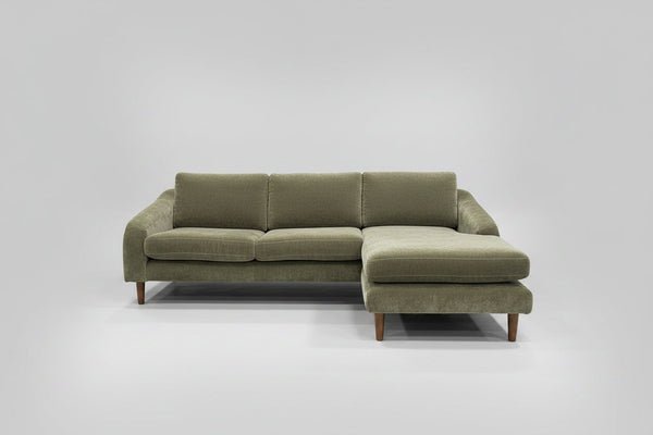 A couch staged in a bright room to capture professional furniture listing photos.
