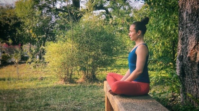 A person sitting with a straight spine and relaxed shoulders.