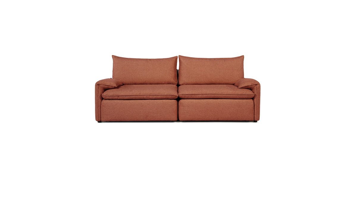 A modern three-seater sofa sits in a bright and spacious living room.
