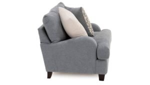 A neutral beige armchair sits in a sunlit living room to demonstrate how wide is an armchair.