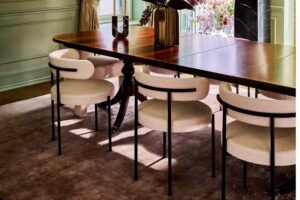 Modern dining chairs arranged around a wooden table in a bright dining room.
