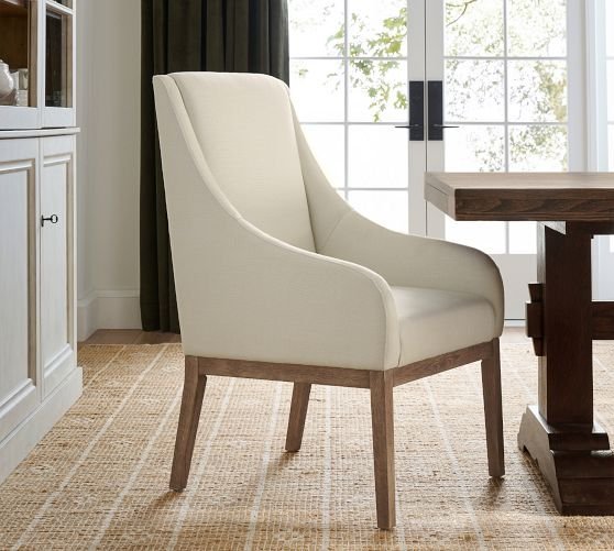Two modern upholstered dining chairs positioned in a bright and minimalist home corner.