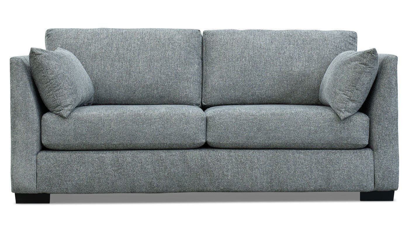 A compact condo sofa with thin track arms fits perfectly in a narrow modern living space.