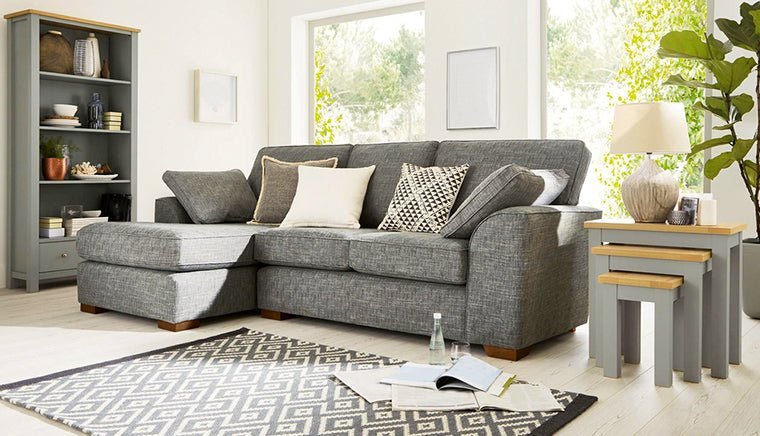 A low-profile sleeper condo sofa arranged in a small apartment corner to maximize living space.