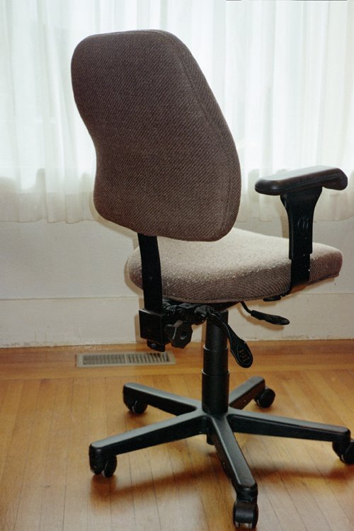 A person adjusting the levers on an ergonomic office chair for a perfect fit.