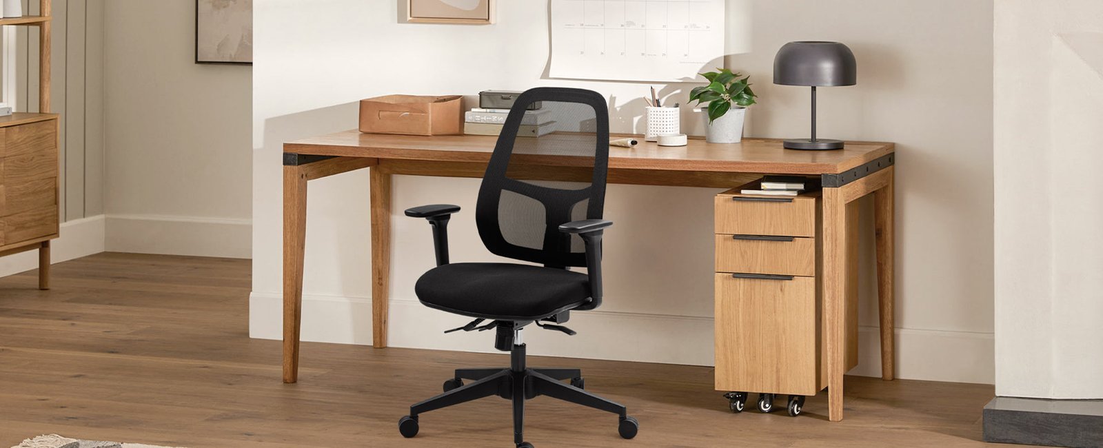 A person adjusts the lumbar support of an ergonomic chair for comfort.