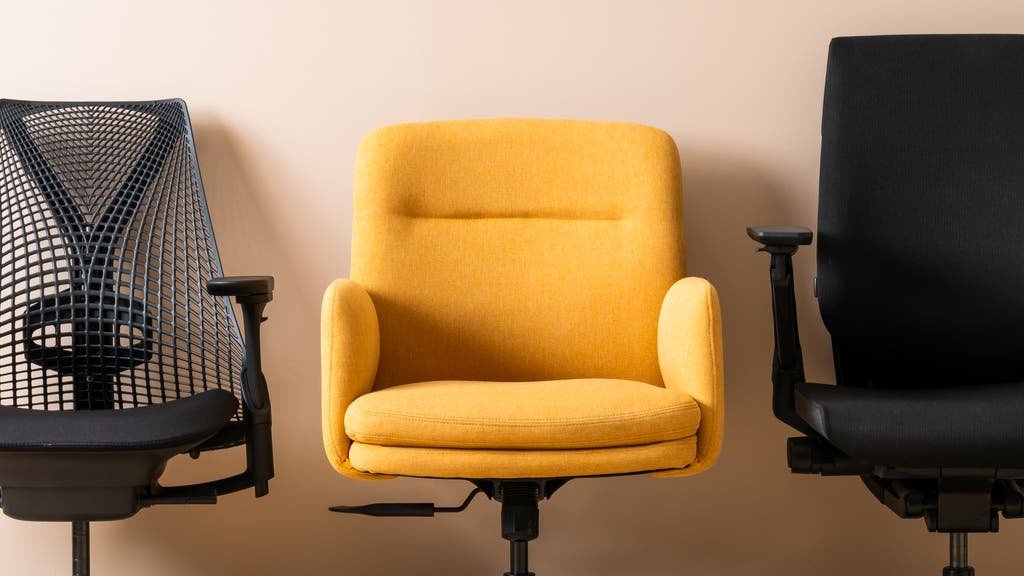 Hands adjusting the height lever of a modern ergonomic office chair for proper posture.