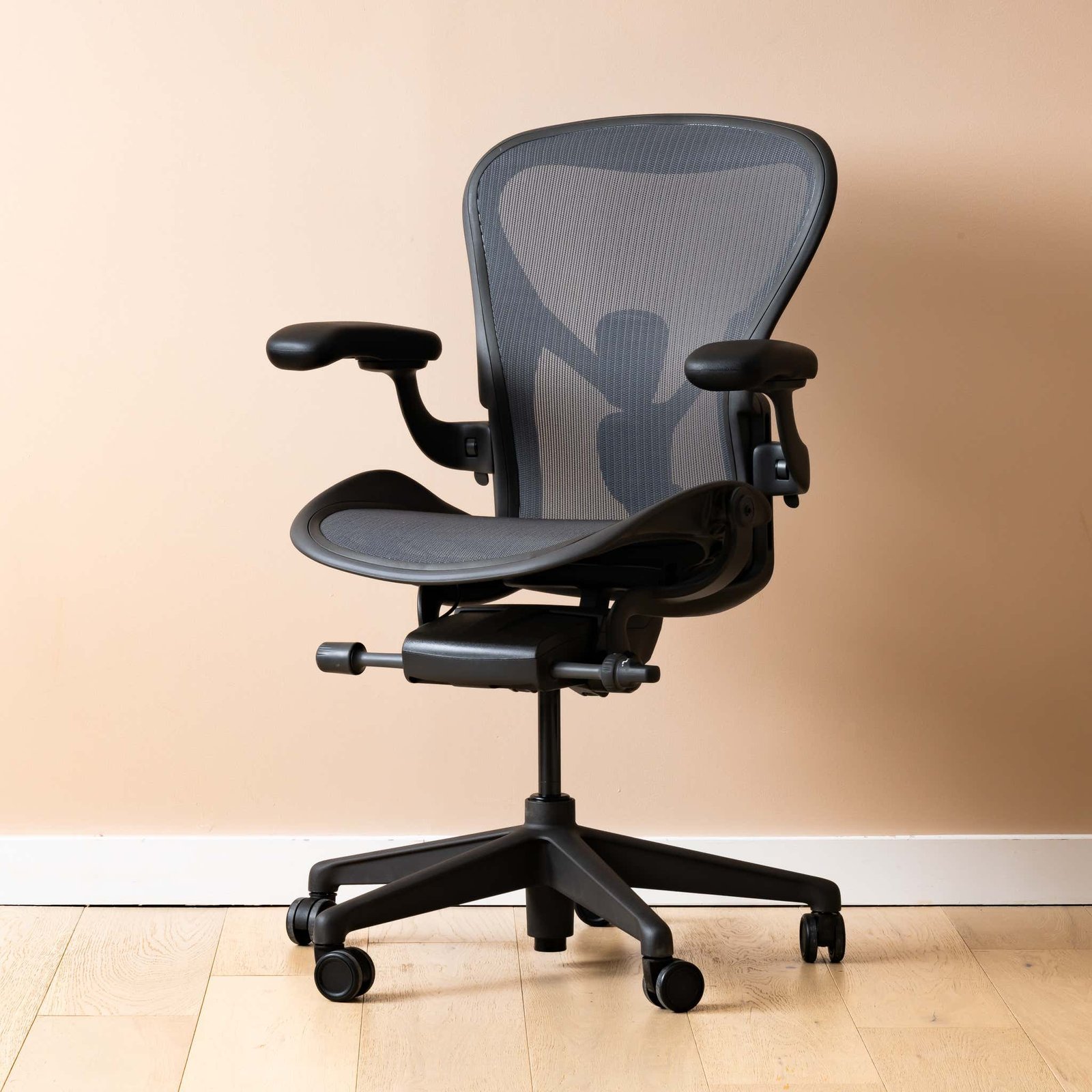A person sitting with perfect posture in an ergonomic office chair at a desk.