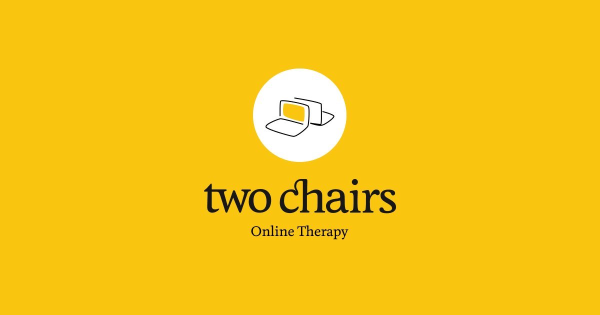A person preparing to move between chairs as part of a therapeutic exercise.