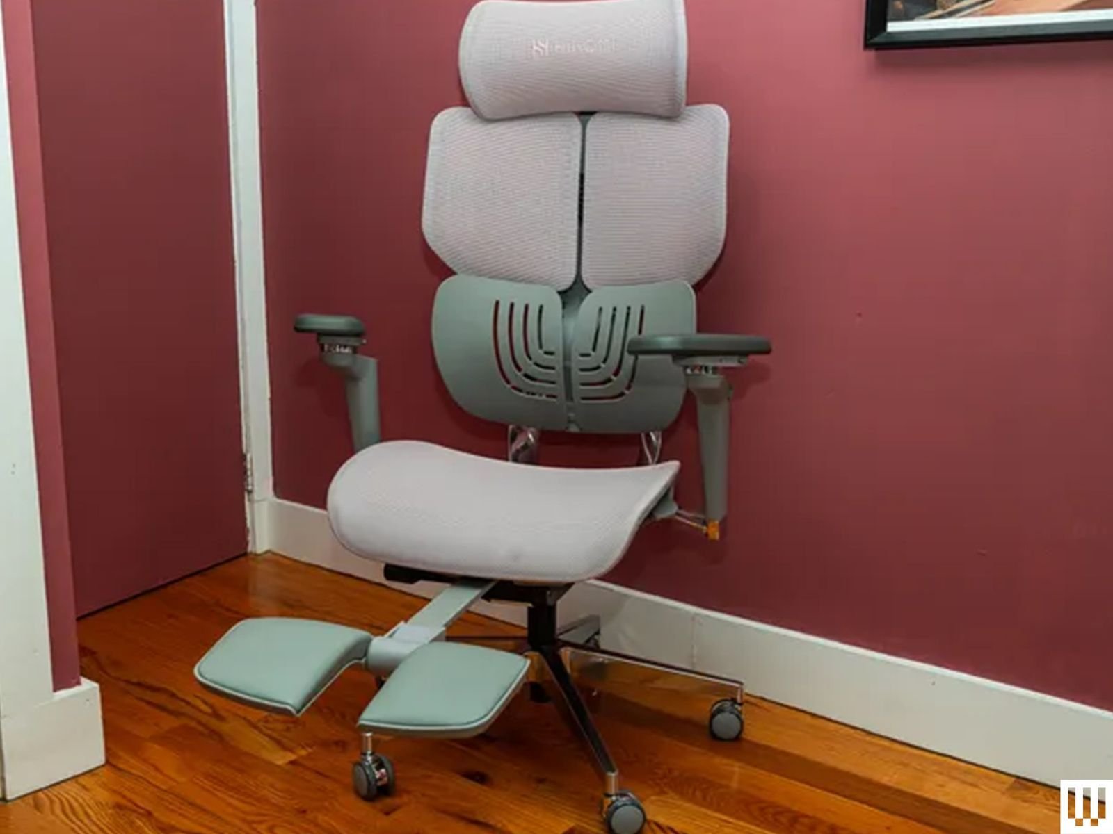 A modern ergonomic office chair sitting in a bright, professional home workspace.