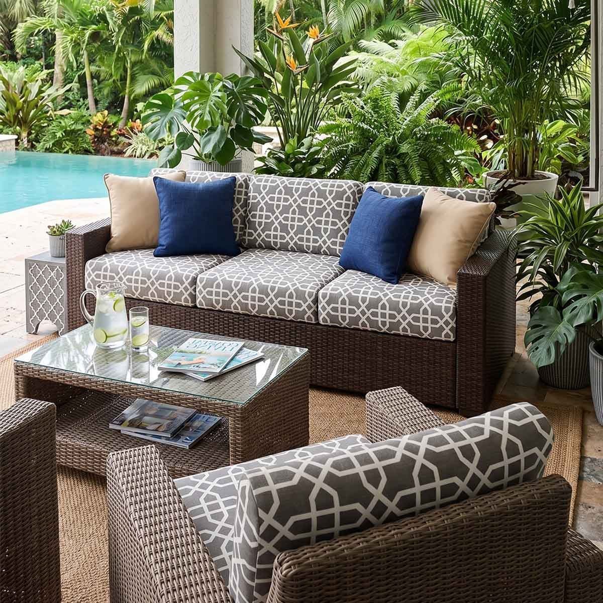 Delivery professionals carefully move a new sofa into a modern home interior.