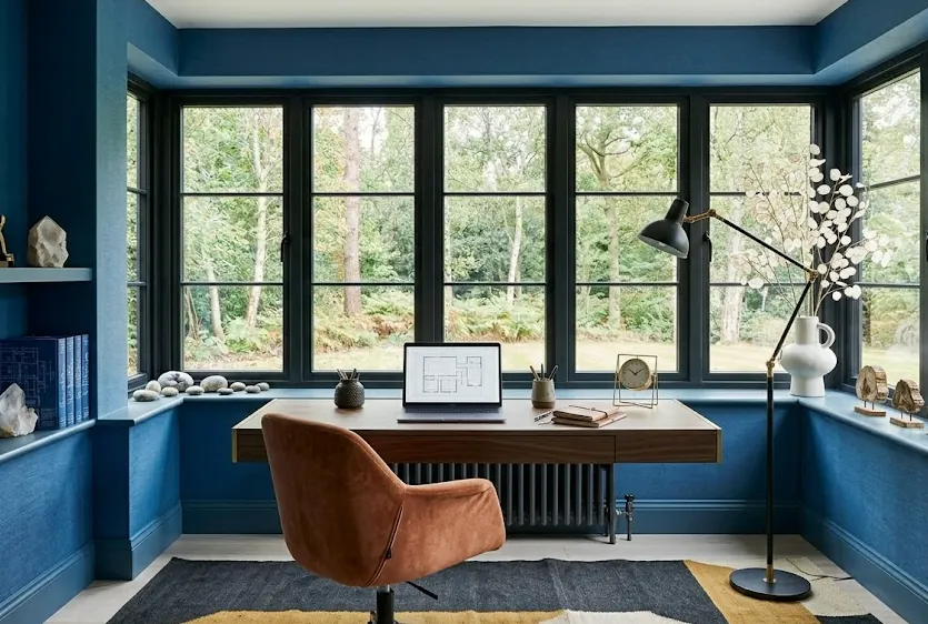 An accent chair sits in the corner of a spacious and tidy bedroom.