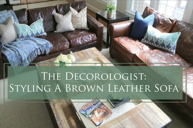 A brown sofa styled with light pillows and a rug to avoid a dull look.