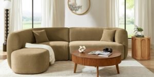 A comfortable, modern sectional couch sits in a brightly lit, clean living room.