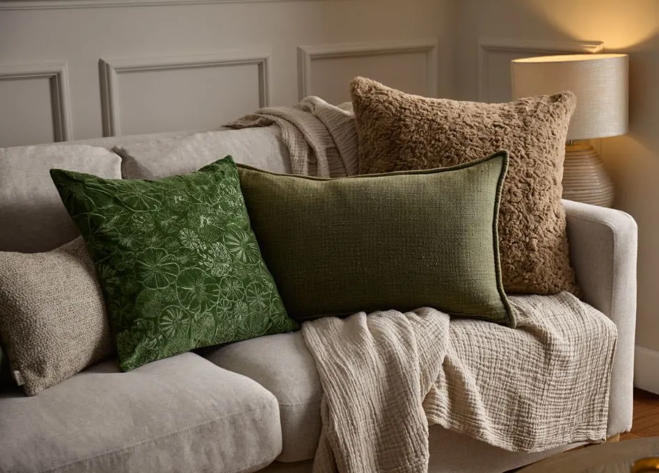 Comparing light and dark decorative pillows on a brown couch for brightness.