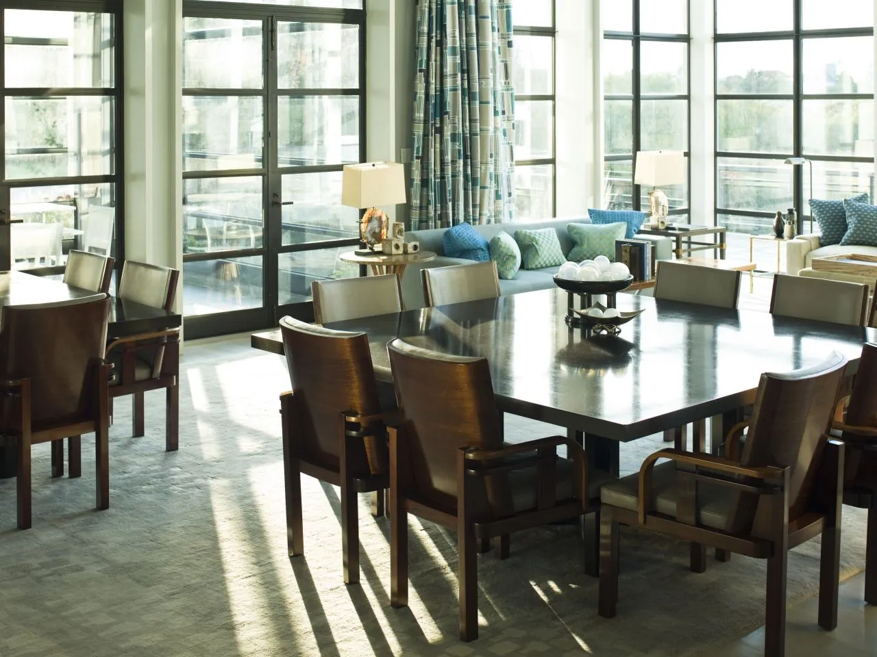 A dining table placed with enough clearance for chairs in a bright room.