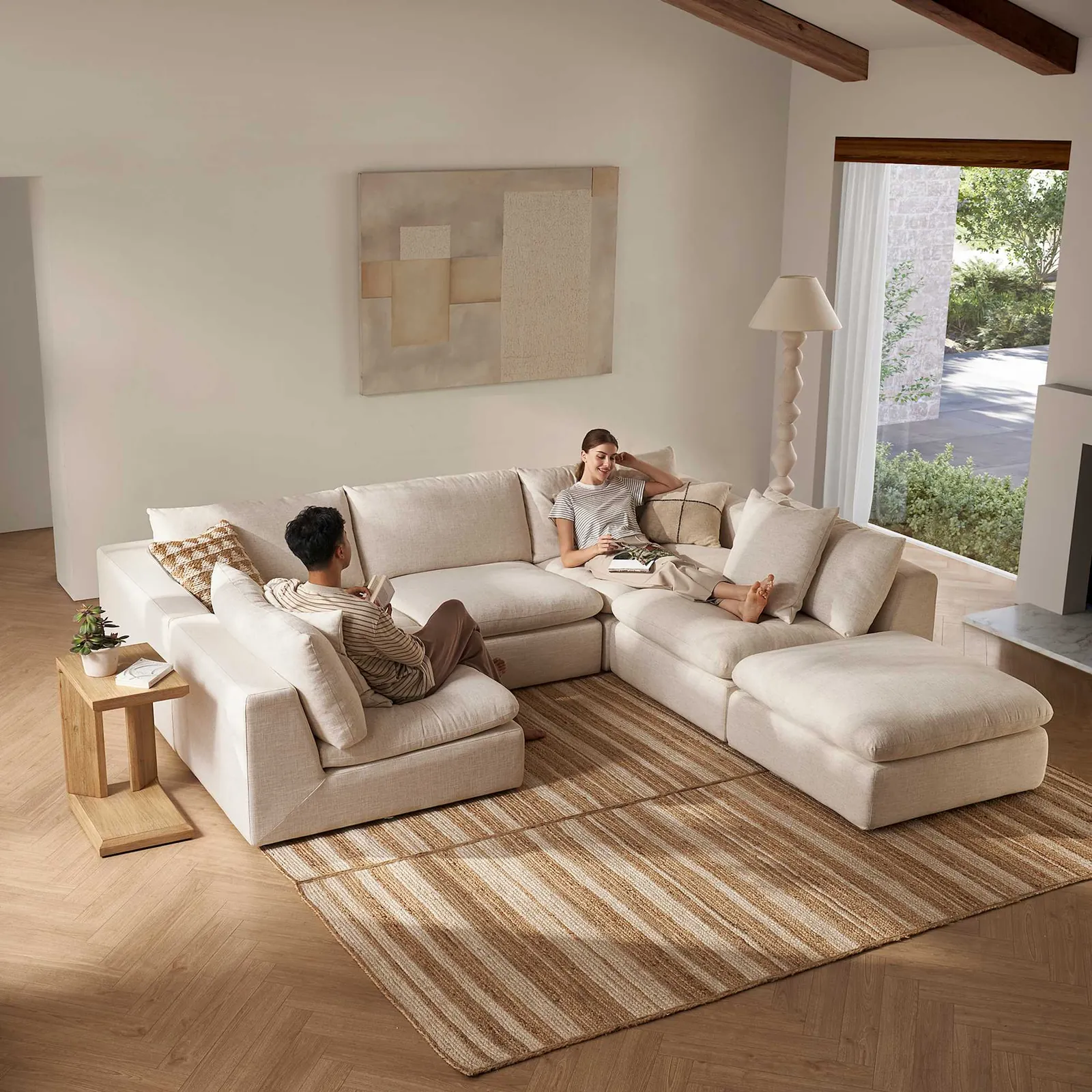 Hands adjusting a sectional sofa cushion to maintain its structural shape.