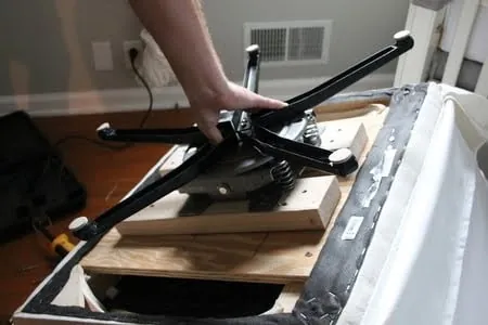Heavy duty swivel plate and assembly hardware arranged on a wooden workbench.