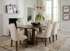 A light oak dining table set with four chairs in a bright room.
