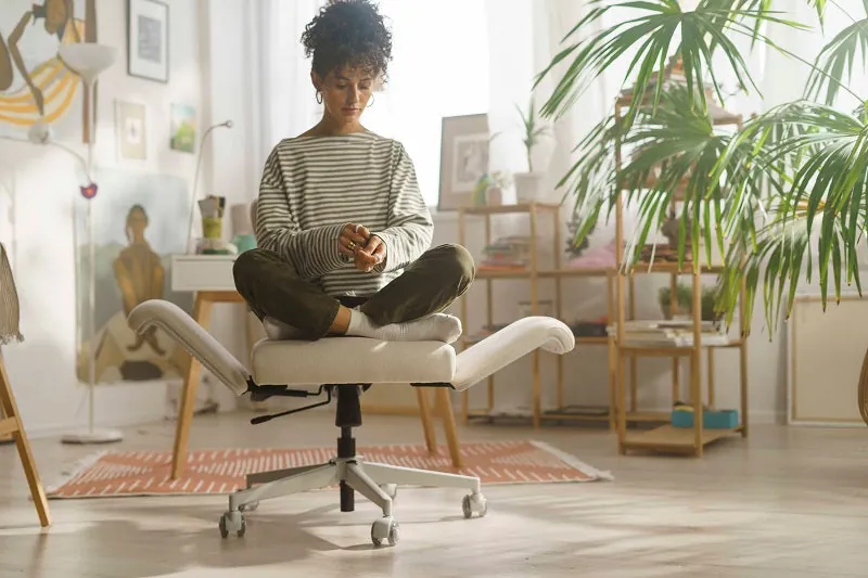 A low task chair positioned under a lowered desk in a bright home office.