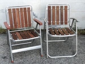 A modern aluminum lawn chair sits gracefully on a lush green lawn.