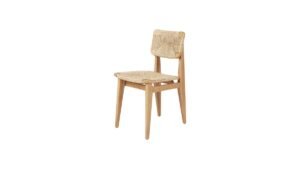 A modern C-chair placed in a bright and minimalist home office setting.