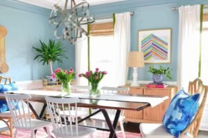 A modern dining table set for a meal in a bright, sunlit room.