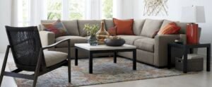 A modern sectional sofa sits in a bright, beautifully decorated contemporary living room.