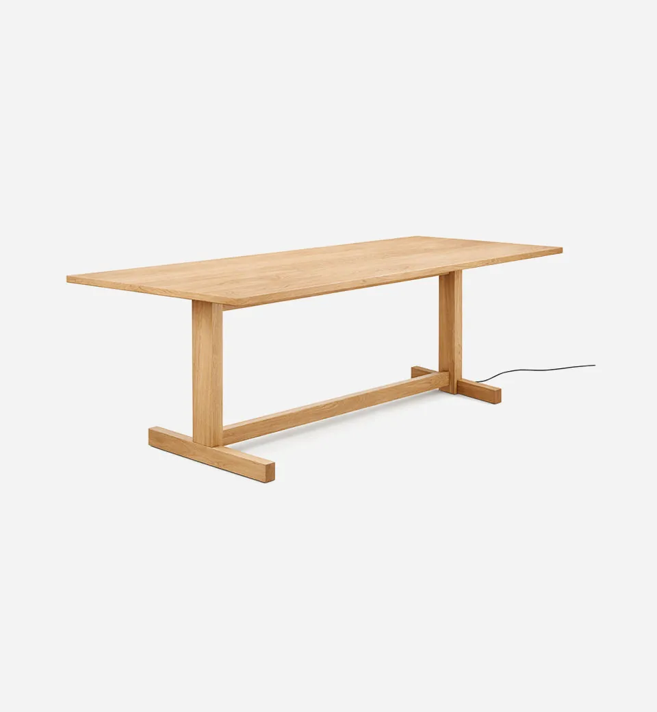 Multiple styles of dining tables displayed in a bright and modern furniture showroom.