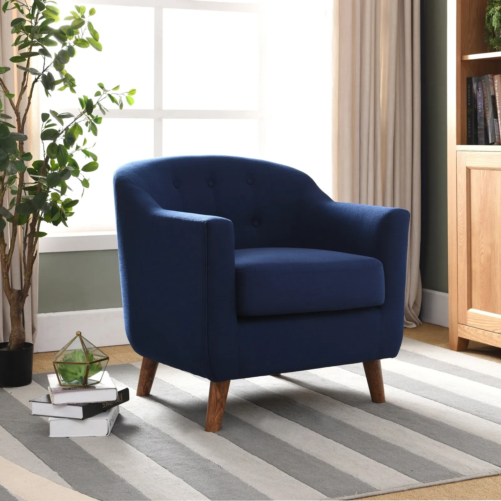 A navy blue accent chair paired with leather furniture in a modern home.