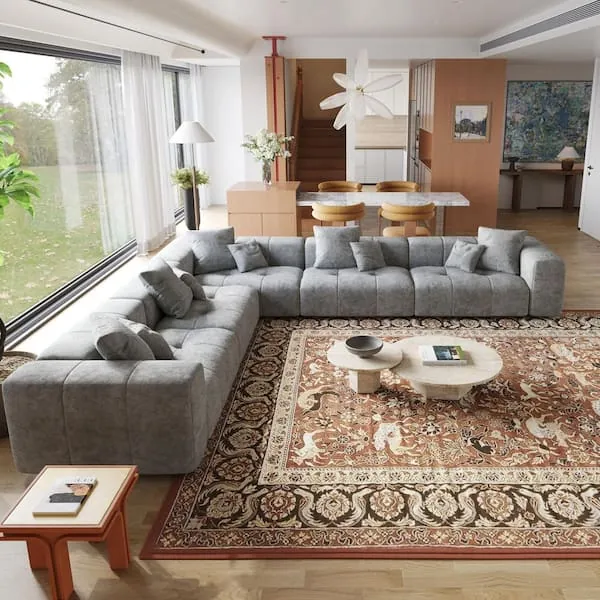 A person arranging modular sectional couch pieces to fit correctly in a living room.