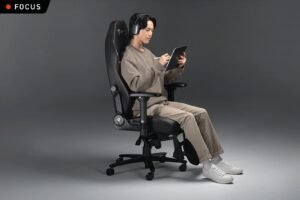 A person installs a swivel mechanism onto a chair seat in a workshop.