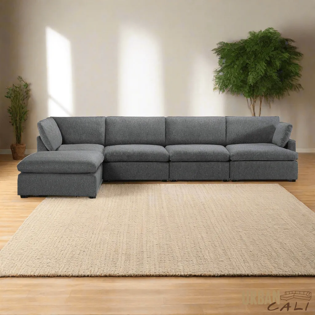 A person measuring the clearance space around a sectional couch in a room.