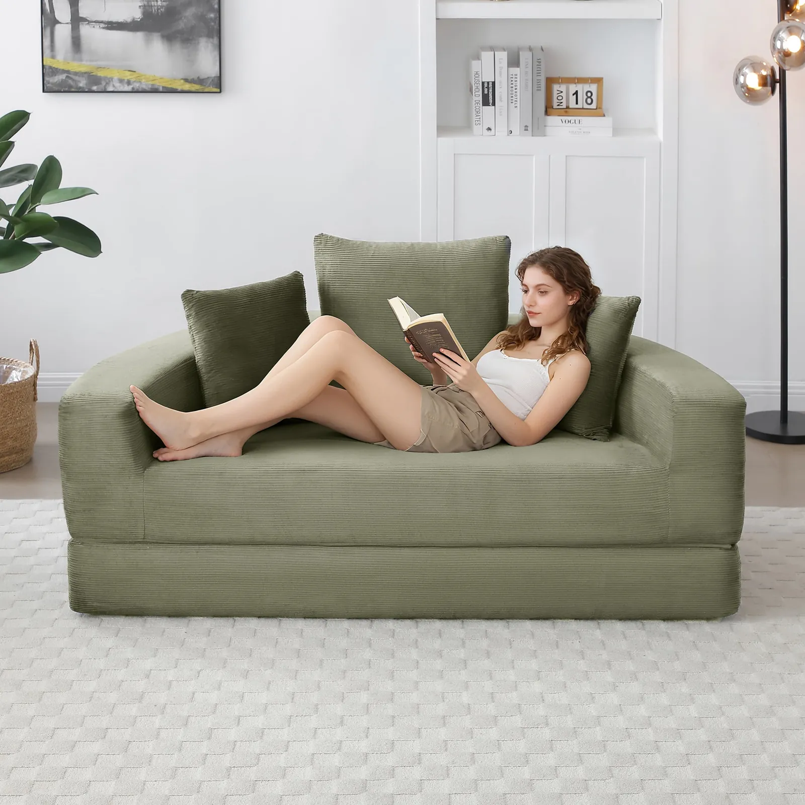 A person testing a comfortable chair bed in a professional furniture showroom environment.