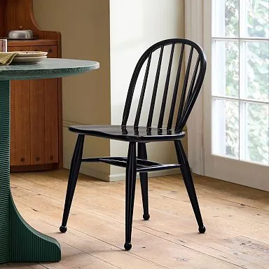 Plastic, steel, and particleboard dining chairs compared side by side indoors.