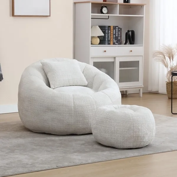 A shaped pillow chair rests on a rug next to stacked hardcover books.
