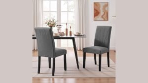 Six simple wooden dining chairs arranged around a table in a bright kitchen.