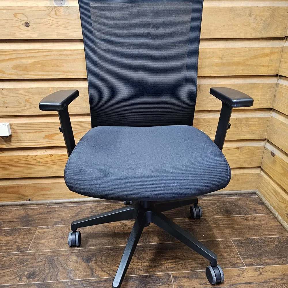 Someone compares different office chair options online while checking fabric samples at home.