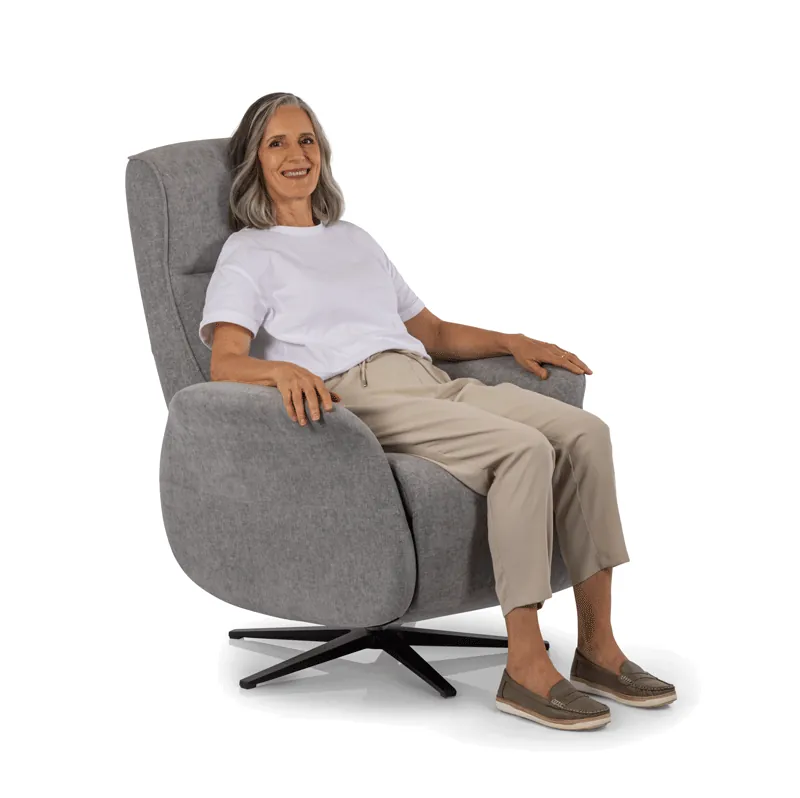 A stationary lift chair sits on a protective floor mat in a living room.