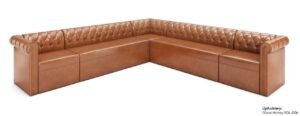 A stylish modern sectional couch sits in a bright, sunlit living room space.
