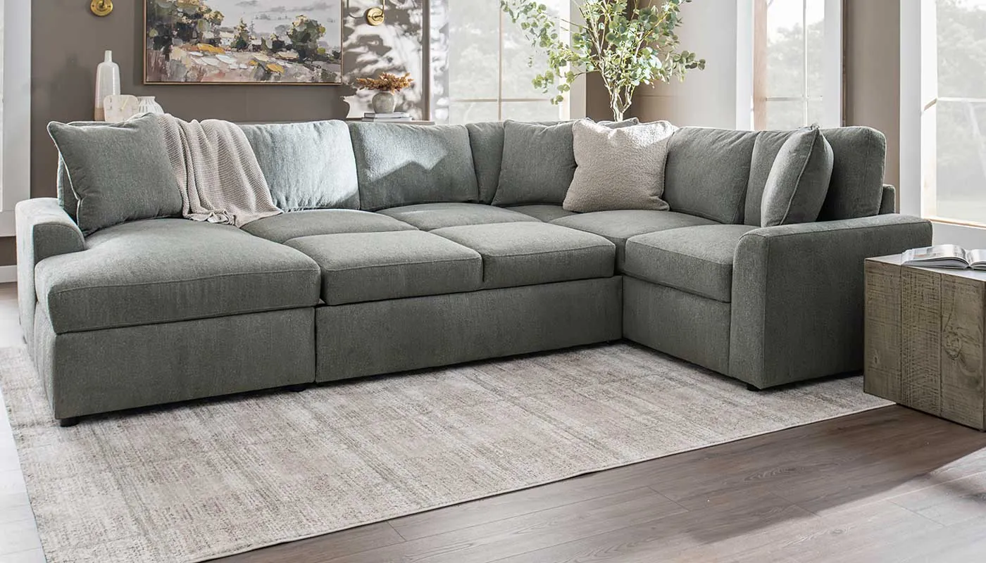 A tape measure lies on the floor beside a chaise sectional layout.