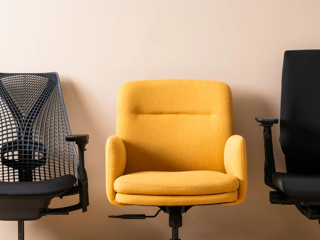 Three different office chairs displayed together on a retail store floor.