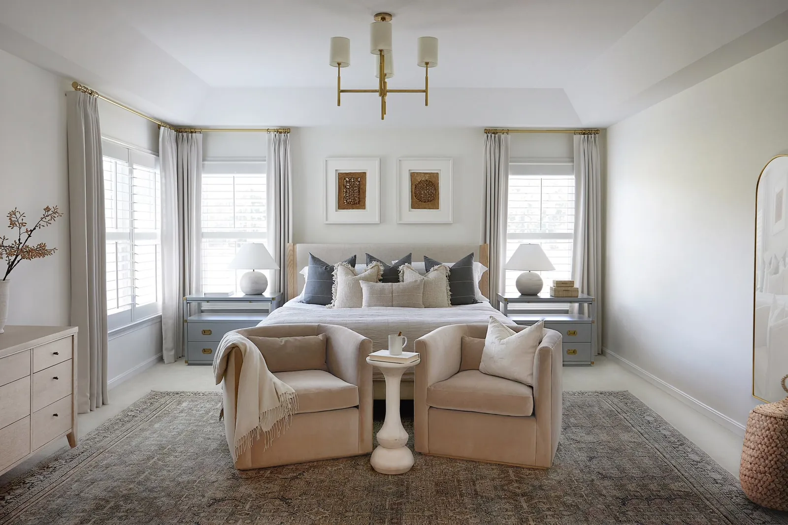 Two armchairs arranged in a master bedroom to create a distinct conversation area.